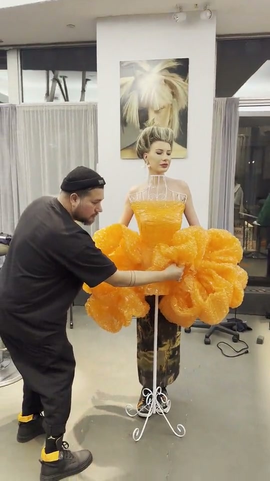 Tony fitting the orange gown on a mannequin