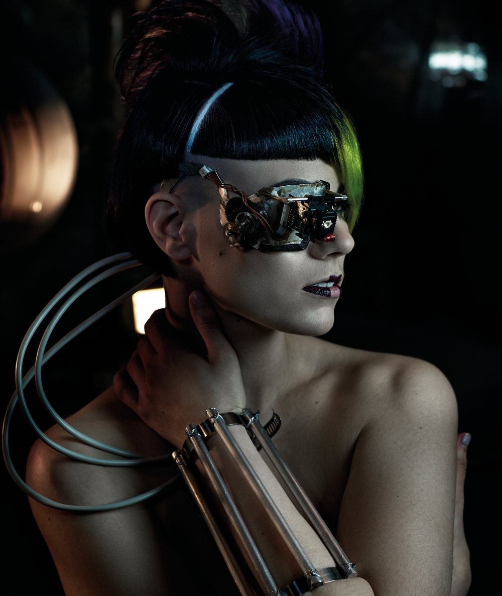 A model with a metal lens over one eye and an armband of tubes
